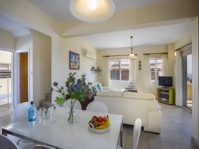 a living room with a couch and a table with a bowl of fruit at Protaras Villa Amber By The Sea in Protaras