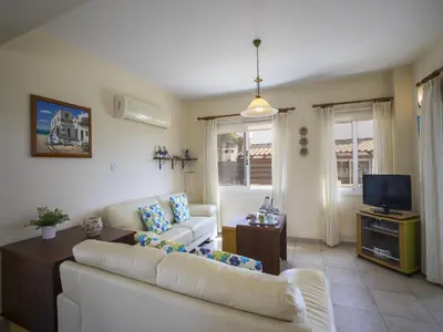 a living room with a couch and a tv at Protaras Villa Amber By The Sea in Protaras