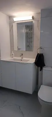 a bathroom with a sink and a toilet and a mirror at Ellas Modern Duplex City Center in Nicosia