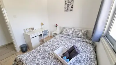 a small bedroom with a bed and a desk at Coastal Getaway: 2 Apartments for up to 14 guests! Light-flooded and Spacious in Larnaka