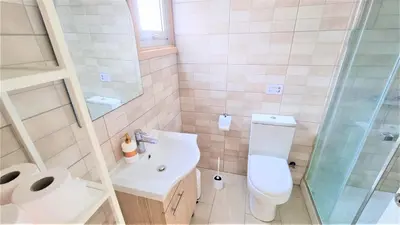 a bathroom with a toilet and a sink and a shower at Coastal Getaway: 2 Apartments for up to 14 guests! Light-flooded and Spacious in Larnaka