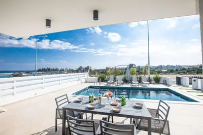 a patio with a table and chairs and a swimming pool at Protaras Holiday Villa TI39 in Paralimni
