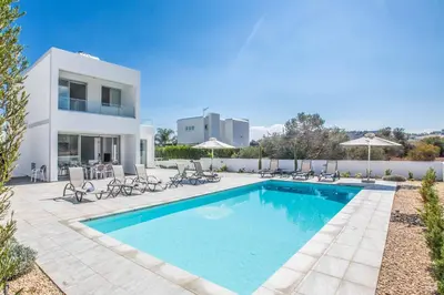 a villa with a swimming pool in front of a house at Protaras Greco Villa CCV5 in Protaras