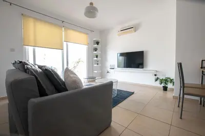 a living room with a gray couch and a tv at Glabur Stays - The Master Atelier - Nicosia City, Free Parking & Wifi, Welcomes You!!! in Nicosia