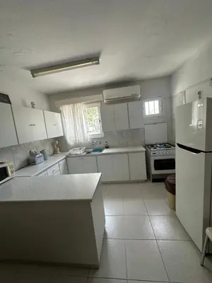 a kitchen with white cabinets and a white refrigerator at Leonidas Seaside in Meneou