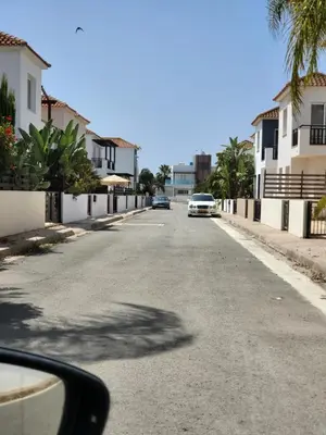 an empty street with a car driving down the road at Villa Joia in Ayia Napa