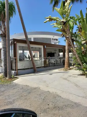 a building with palm trees in front of it at Villa Joia in Ayia Napa