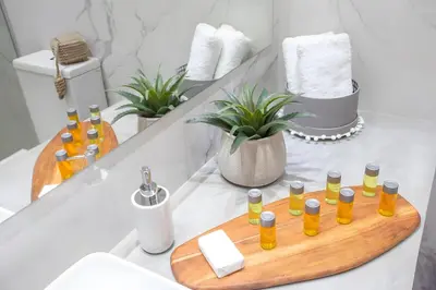 a bathroom with a wooden tray with essential oils on a counter at Sun & Sea Seaview Apartment in Protaras