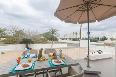 a table with food and an umbrella on a balcony at Sun & Sea Seaview Apartment in Protaras