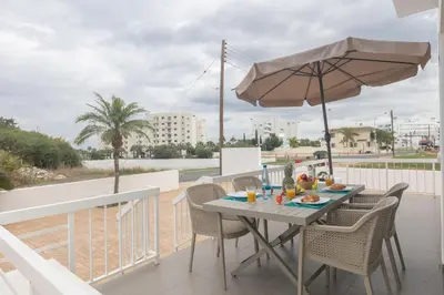 a table and chairs with an umbrella on a balcony at Sun & Sea Seaview Apartment in Protaras