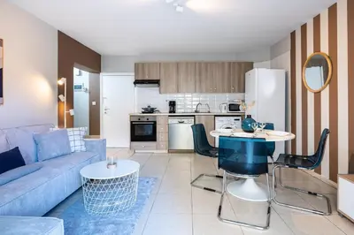 a living room with a blue couch and a table at Gitane 1-Bedroom Apartment in Larnaca in Larnaka