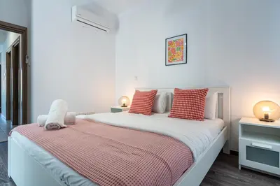 a bedroom with a bed with red and white pillows at Crystal 2-Bedroom Apartment in Larnaca in Larnaka
