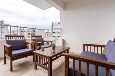 a balcony with chairs and a table on a building at Celeste 3-Bedroom Apartment in Larnaca in Larnaka