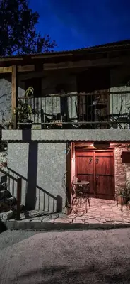 a house with a wooden door and a table in front at Angels Traditional House in Arminou
