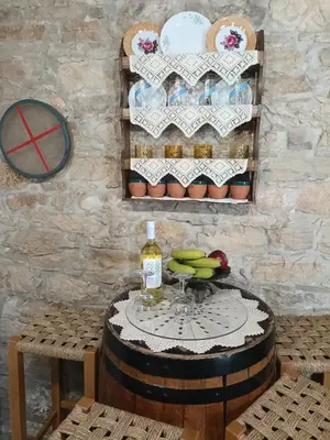 a table with a bottle of wine and bananas on a barrel at Angels Traditional House in Arminou