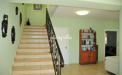 a staircase in a living room with a book shelf at LULA VILLA in Ayia Napa