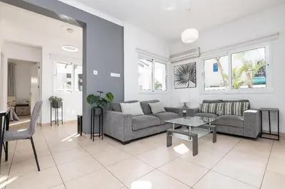 a living room with a couch and a table at Lindos Villa Ekaterina in Paralimni