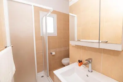 a bathroom with a sink and a shower and a toilet at Lindos Villa Ekaterina in Paralimni