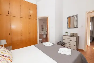a bedroom with a bed and a sink and a mirror at Lindos Villa Ekaterina in Paralimni