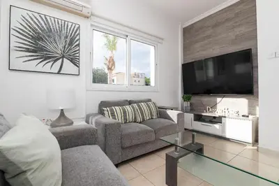 a living room with a couch and a flat screen tv at Lindos Villa Ekaterina in Paralimni
