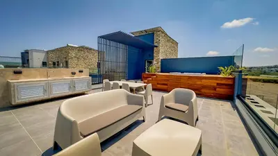 a patio with white chairs and tables on a roof at Sunrise Beachfront Villas - Villa 1 in Paralimni