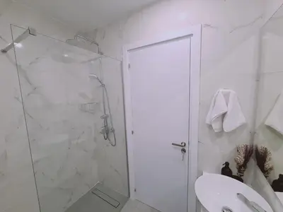 a white bathroom with a shower and a sink at STAY Anemone 19 in Protaras