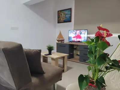 a living room with a couch and a tv at Palm Sea Suite 17 in Larnaka