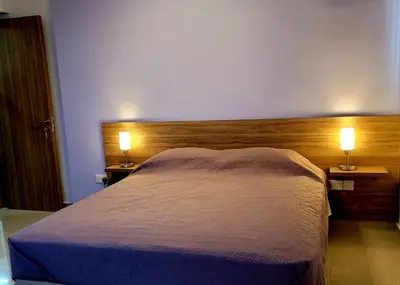 a bedroom with a bed with two lights on it at Palm Sea Suite 17 in Larnaka