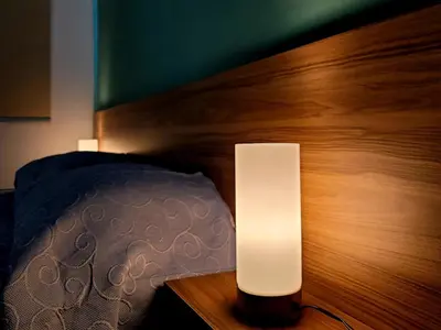 a bedroom with a bed and a lamp on a wooden headboard at Palm Sea Suite 17 in Larnaka