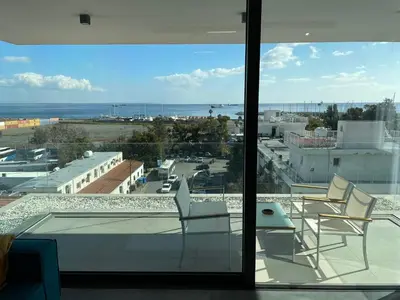 a balcony with chairs and a view of a city at Gaia Seaview Apartment 1 in Larnaka