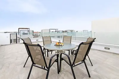 a table and chairs on the roof of a building at Villa Queen Alexandra in Protaras