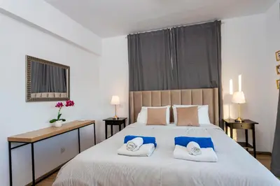a bedroom with a large bed with towels on it at Palm Beach Apartment by TrulyCyprus in Limassol