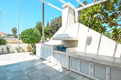 a patio with an outdoor kitchen and stairs at Villa 361-Walk to Protaras Fig Tree Bay & Amenities in Protaras