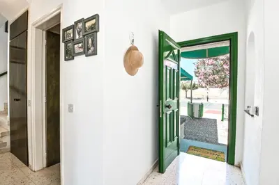 a hallway with a green door leading to a patio at Villa 361-Walk to Protaras Fig Tree Bay & Amenities in Protaras