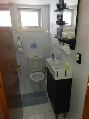 a bathroom with a toilet and a sink and a window at Kyri's Place Larnaca in Larnaka