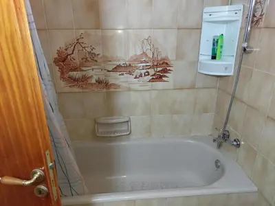 a bath tub in a bathroom with a painting on the wall at Kyri's Place Larnaca in Larnaka