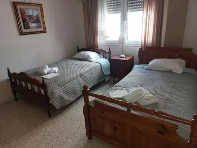 a bedroom with two twin beds and a window at Kyri's Place Larnaca in Larnaka