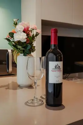 a bottle of wine and a wine glass on a counter at Mythical Spa Suite - GYM*Yoga Room*Pools in Protaras
