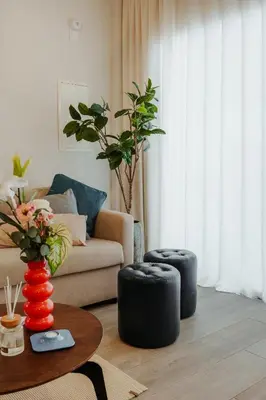 a living room with a couch and two black stools at Mythical Spa Suite - GYM*Yoga Room*Pools in Protaras