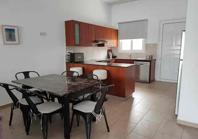 a kitchen with a table and chairs in a room at Villa Poseidon in Pervolia