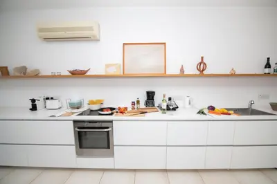 a kitchen with white cabinets and a counter top at Jasmine Sea Front Villa in Protaras