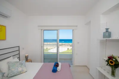 a bedroom with a bed and a view of the ocean at Jasmine Sea Front Villa in Protaras