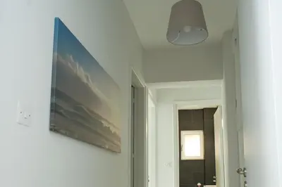 a hallway with a painting on the wall and a light fixture at ALEX APARTMENT in Strovolos