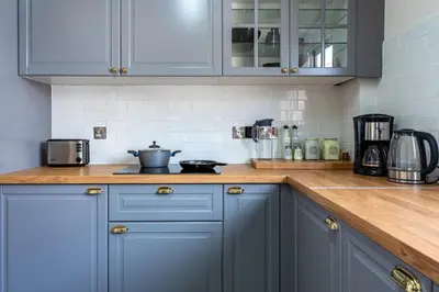 a kitchen with blue cabinets and a counter top at Vox 2-Bedroom Apartment in Larnaca in Larnaka