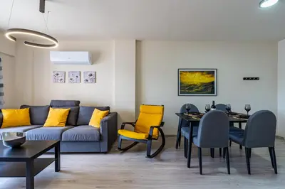 a living room with a couch and a table and chairs at Vox 2-Bedroom Apartment in Larnaca in Larnaka