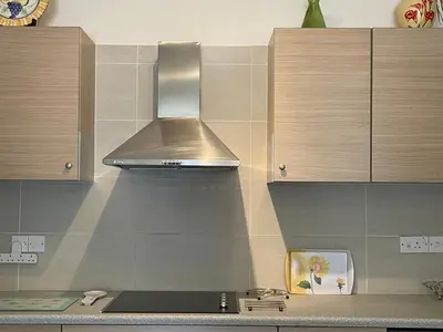 a kitchen with a stainless steel hood over a stove at Belleview Heights in Limassol
