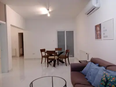 a living room with a couch and a table and chairs at Zelea Deluxe Apartment (BREAKBOOKING CY) in Limassol