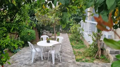 a white table and chairs in a garden at Elpida Lemon Garden House in Limassol