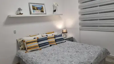 a white bedroom with a bed with pillows at Elpida Lemon Garden House in Limassol