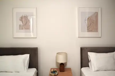 a bedroom with two beds and two pictures on the wall at Pebble in Protaras
